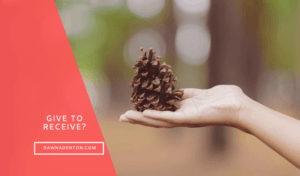 an open hand with a pine cone
