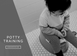 a toddler sitting on their potty as part of their potty training